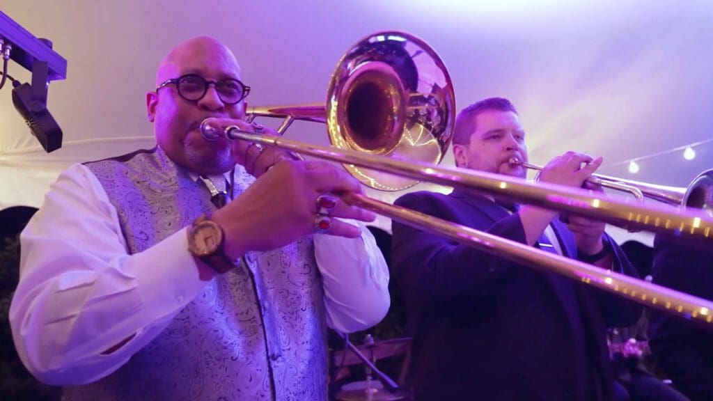 Trombone player performing in live band at wedding