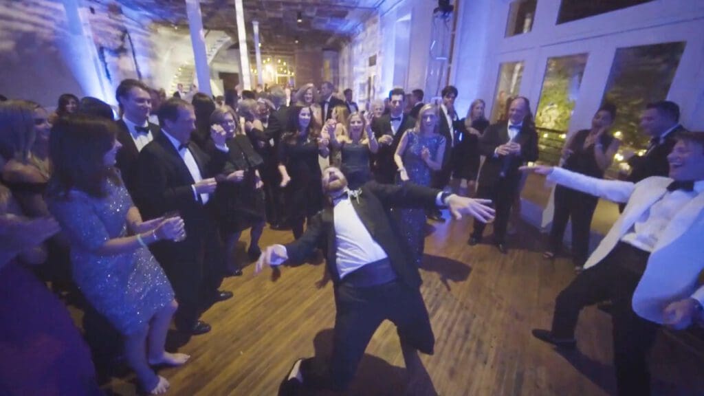 Groom dancing during wedding reception to live wedding band